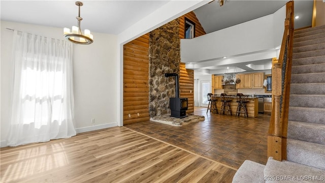 15 Rose Wind Ln, Brumley, MO 65017 - living area featuring log walls, stairs, a wood stove, baseboards, and wood finished floors