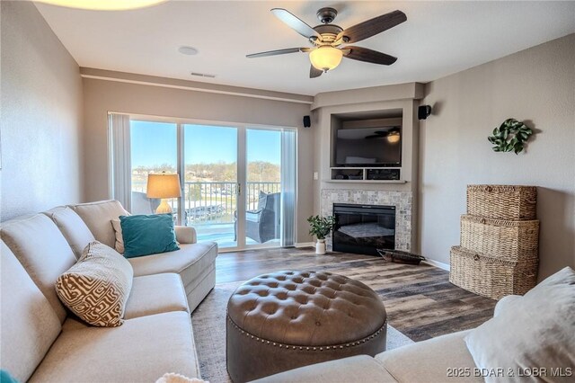 1359 Seascape Ln Unit A-501, Osage Beach, MO 65065 - living room with a ceiling fan, wood finished floors, a glass covered fireplace, and baseboards