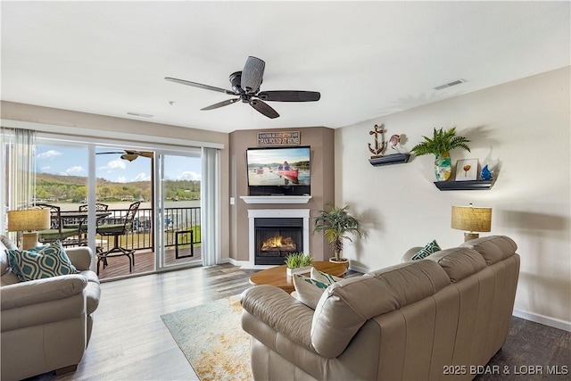 686 Clearwater Dr Unit 2E, Camdenton, MO 65020 - living room featuring ceiling fan, wood finished floors, and a fireplace with flush hearth