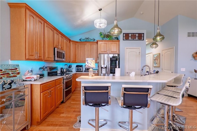 5218 Big Ship St, Osage Beach, MO 65065 - kitchen featuring visible vents, light countertops, light wood-type flooring, a kitchen bar, and stainless steel appliances