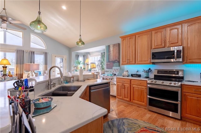 5218 Big Ship St, Osage Beach, MO 65065 - kitchen with vaulted ceiling, appliances with stainless steel finishes, light wood finished floors, pendant lighting, and a sink