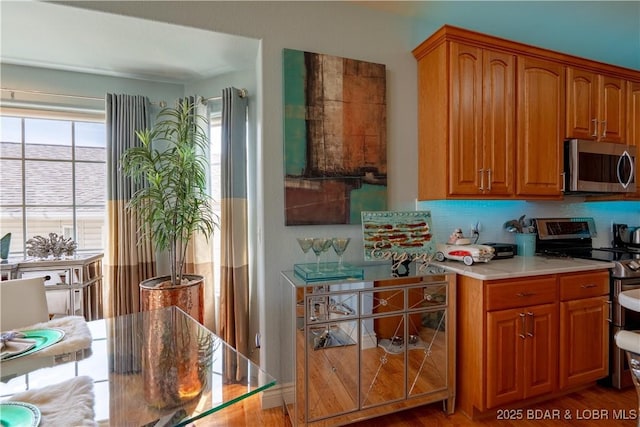 5218 Big Ship St, Osage Beach, MO 65065 - kitchen featuring stainless steel appliances, tasteful backsplash, light countertops, and brown cabinetry