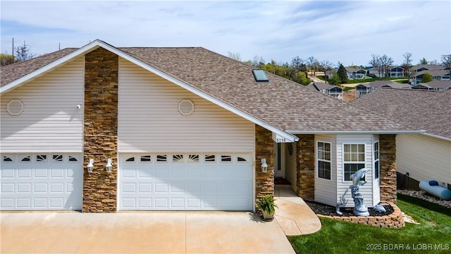 5218 Big Ship St, Osage Beach, MO 65065 - view of front of property with a garage, driveway, stone siding, and a shingled roof