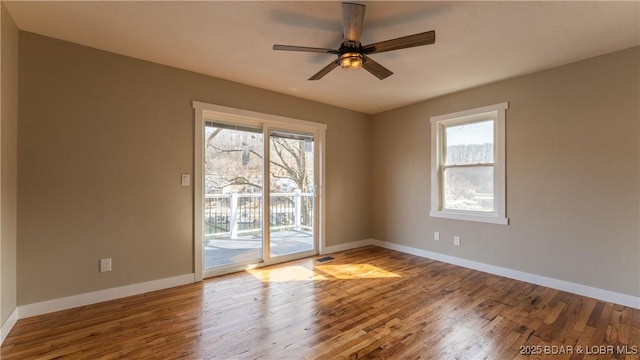 unfurnished room featuring wood finished floors, baseboards, and ceiling fan