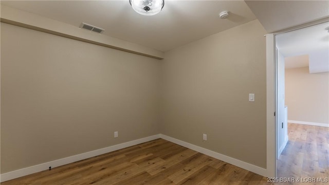spare room featuring light wood finished floors and baseboards