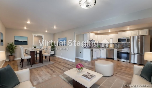 living area featuring light wood-style flooring, baseboards, and recessed lighting
