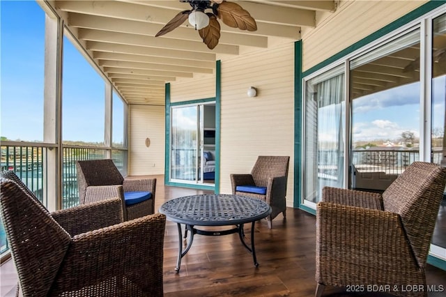 sunroom / solarium featuring ceiling fan and beamed ceiling