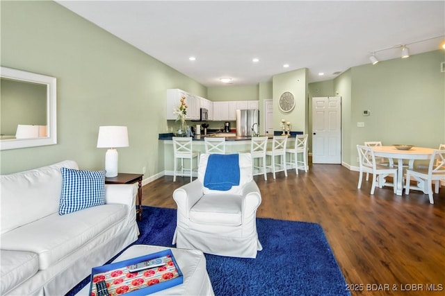 living area with dark wood finished floors, baseboards, and recessed lighting