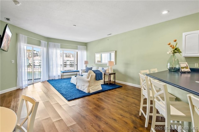 living room featuring dark wood finished floors, baseboards, and recessed lighting