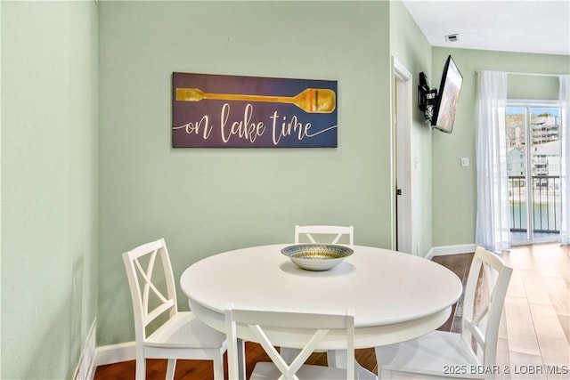 dining area with wood finished floors and baseboards