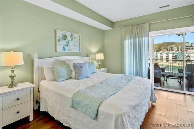 bedroom with dark wood finished floors and access to outside