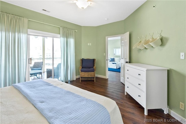 bedroom with multiple windows, dark wood finished floors, and baseboards