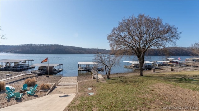 view of dock with a yard and a water view