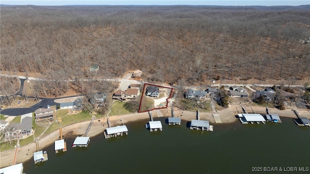 drone / aerial view featuring a residential view, a view of trees, and a water view