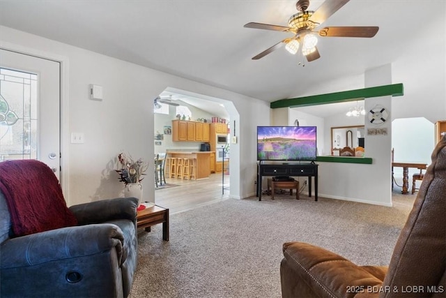 663 Highlands Dr, Camdenton, MO 65020 - living area featuring vaulted ceiling, ceiling fan with notable chandelier, arched walkways, light colored carpet, and baseboards