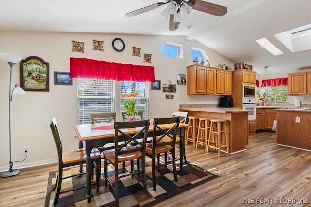 663 Highlands Dr, Camdenton, MO 65020 - dining space with light wood-style floors, lofted ceiling with skylight, and a ceiling fan