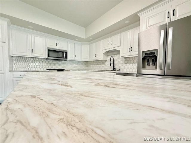 245 Davis Dr, Holts Summit, MO 65043 - kitchen with white cabinets, stainless steel appliances, a sink, and light stone counters