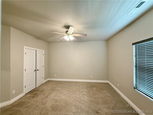 245 Davis Dr, Holts Summit, MO 65043 - carpeted spare room with visible vents, a ceiling fan, and baseboards