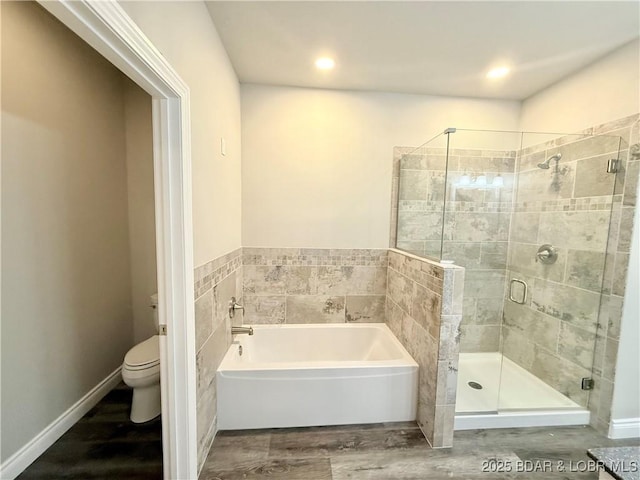 245 Davis Dr, Holts Summit, MO 65043 - full bathroom featuring a bath, toilet, recessed lighting, wood finished floors, and a shower stall