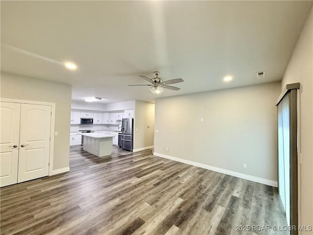 245 Davis Dr, Holts Summit, MO 65043 - unfurnished living room featuring ceiling fan, baseboards, wood finished floors, and recessed lighting