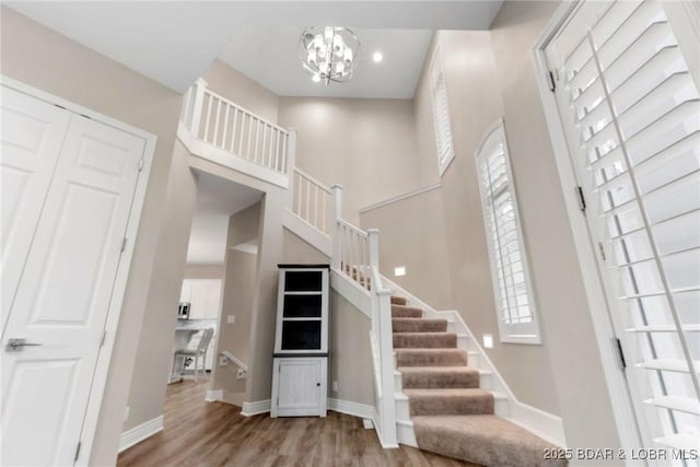 275 Waterford Ter, Sunrise Beach, MO 65079 - foyer featuring a towering ceiling, wood finished floors, baseboards, a chandelier, and stairs