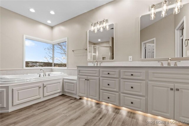 275 Waterford Ter, Sunrise Beach, MO 65079 - full bathroom featuring a sink, double vanity, a stall shower, wood finished floors, and a garden tub