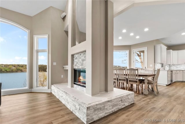 275 Waterford Ter, Sunrise Beach, MO 65079 - living area featuring recessed lighting, light wood-style flooring, and a multi sided fireplace