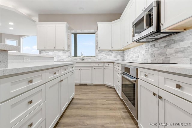 275 Waterford Ter, Sunrise Beach, MO 65079 - kitchen featuring white cabinets, stainless steel appliances, light wood-style flooring, recessed lighting, and decorative backsplash