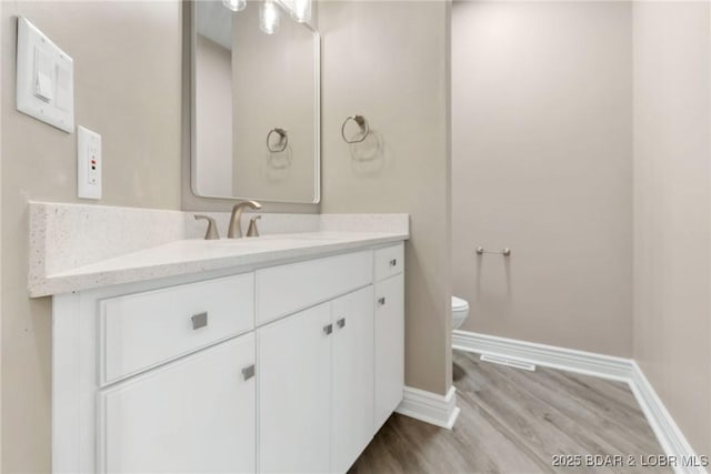 275 Waterford Ter, Sunrise Beach, MO 65079 - bathroom featuring wood finished floors, baseboards, vanity, and toilet