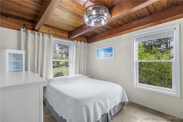 bedroom with wooden ceiling, light tile patterned flooring, multiple windows, and beamed ceiling