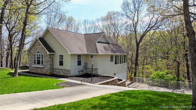 101 Cliffstone Ln, Sunrise Beach, MO 65079 - view of home's exterior featuring a garage, a shingled roof, stone siding, and concrete driveway