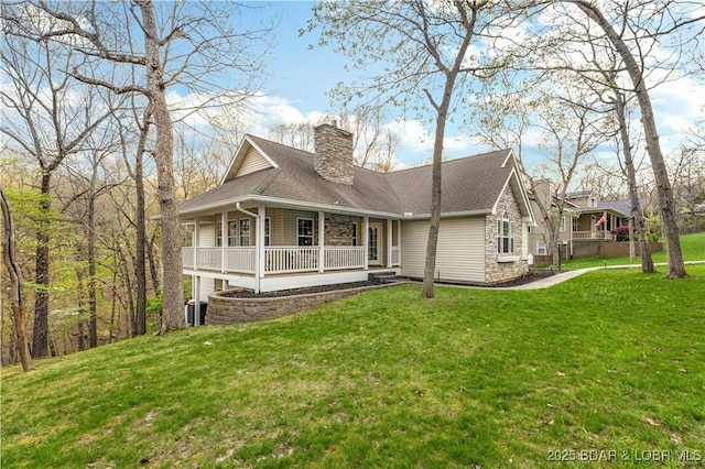 101 Cliffstone Ln, Sunrise Beach, MO 65079 - view of front of home featuring a porch, a chimney, a front yard, and stone siding