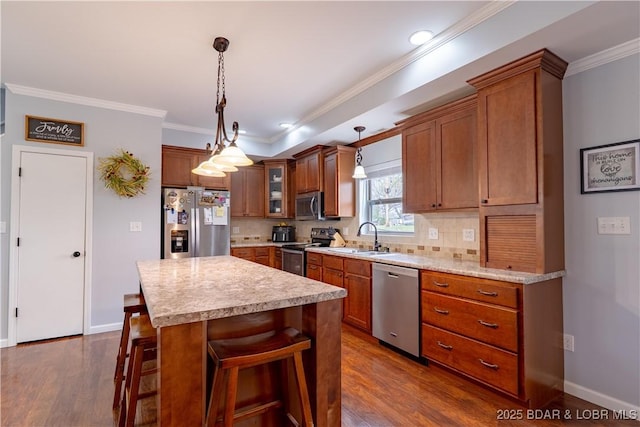 kitchen with light countertops, brown cabinetry, appliances with stainless steel finishes, and a sink