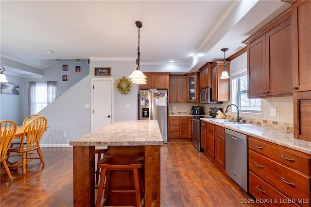 kitchen featuring dark wood-style flooring, decorative backsplash, brown cabinets, appliances with stainless steel finishes, and ornamental molding