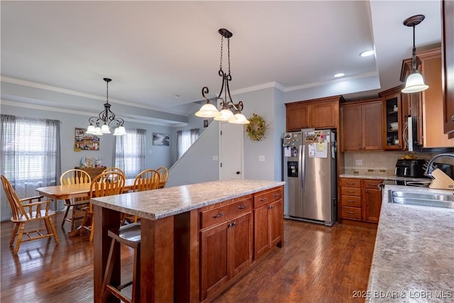 kitchen featuring dark wood finished floors, stainless steel fridge with ice dispenser, a sink, and an inviting chandelier