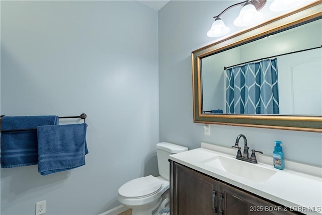 bathroom with a shower with curtain, baseboards, vanity, and toilet