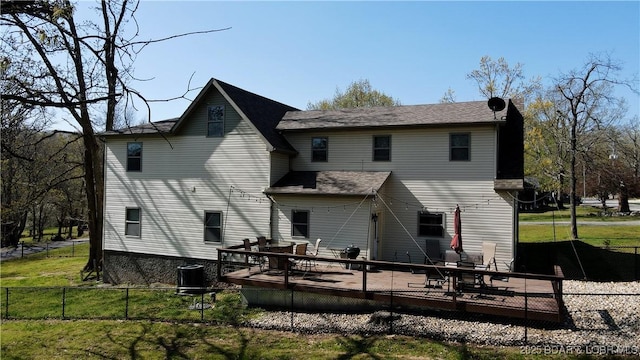 rear view of house with a fenced backyard, central AC unit, a deck, and a lawn