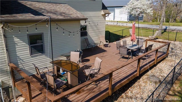 wooden deck with outdoor dining area and fence