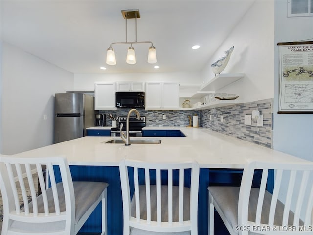 24930 Leona Ln, Versailles, MO 65084 - kitchen with a peninsula, appliances with stainless steel finishes, open shelves, and tasteful backsplash