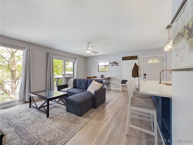 24930 Leona Ln, Versailles, MO 65084 - living room featuring light wood-type flooring, visible vents, a ceiling fan, and baseboards