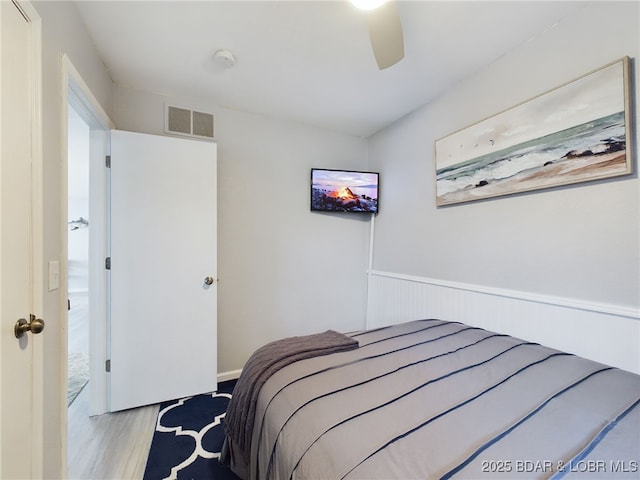 24930 Leona Ln, Versailles, MO 65084 - bedroom with wood finished floors, visible vents, a ceiling fan, and wainscoting