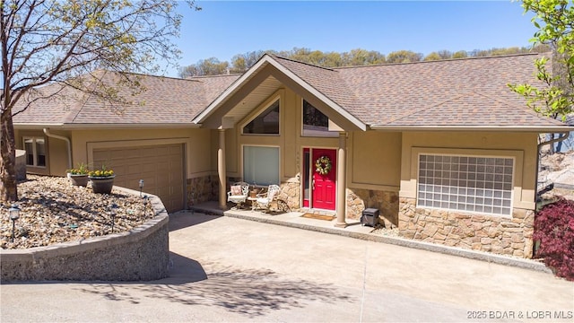 6605 Saint Moritz Dr, Osage Beach, MO 65065 - single story home featuring a shingled roof, concrete driveway, an attached garage, stucco siding, and stone siding