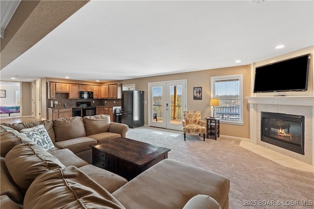 living room featuring light colored carpet, baseboards, a tile fireplace, and recessed lighting