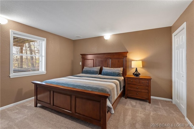 bedroom featuring baseboards, visible vents, light colored carpet, and a textured wall