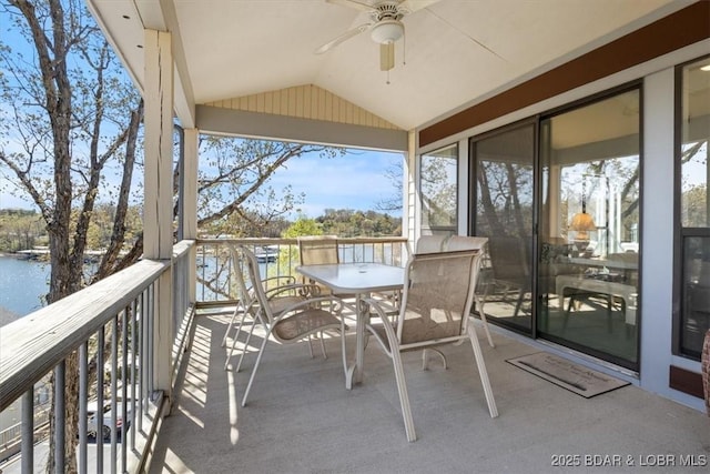 balcony with a water view, a ceiling fan, and outdoor dining space