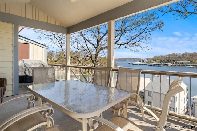 balcony with a grill, a water view, and outdoor dining space