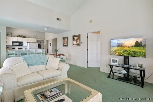 living room with high vaulted ceiling, carpet flooring, and visible vents