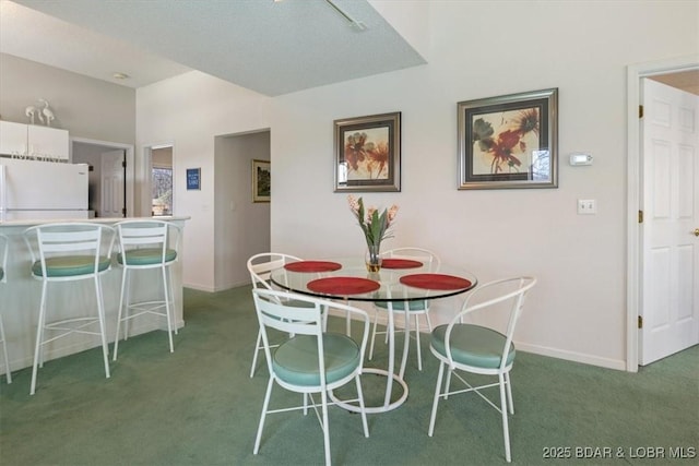 carpeted dining space featuring baseboards