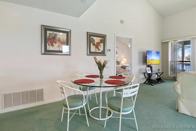 dining space featuring high vaulted ceiling, baseboards, visible vents, and carpet