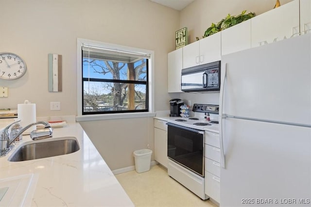 kitchen featuring a sink, baseboards, white cabinetry, white appliances, and light stone counters